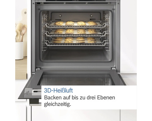 Innenansicht eines Backofens mit drei Rosten voller Kekse