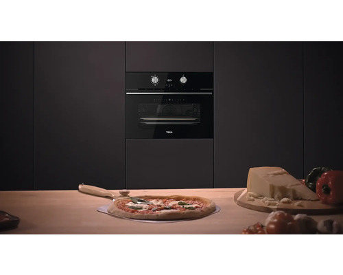 Schwarzer Einbaubackofen von Teka in einer modernen Küche mit Pizza und Zutaten auf der Arbeitsfläche.