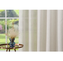 Dekorative Fenstergardine mit Pflanzenarrangement auf kleinem Tisch