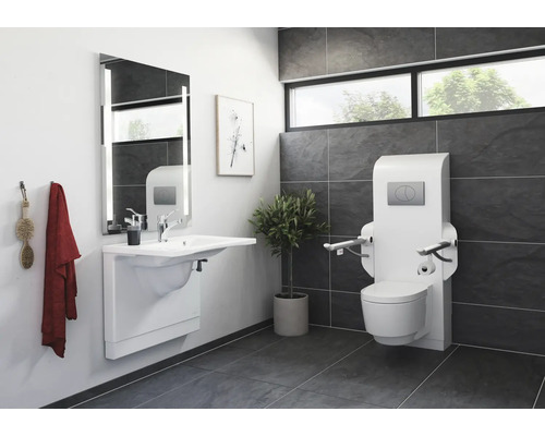 Barrierefreies Badezimmer mit Waschtisch, Spiegel und Toilette mit Haltegriffen