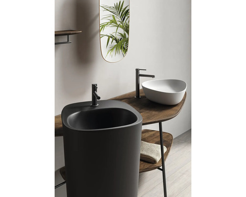 Badezimmerinterieur mit schwarzem Standwaschbecken, Aufsatzwaschbecken, Armaturen und Spiegel