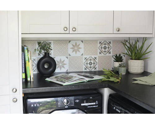 Wäscheküche mit Waschmaschine, Arbeitsplatte, Fliesen und dekorativen Elementen