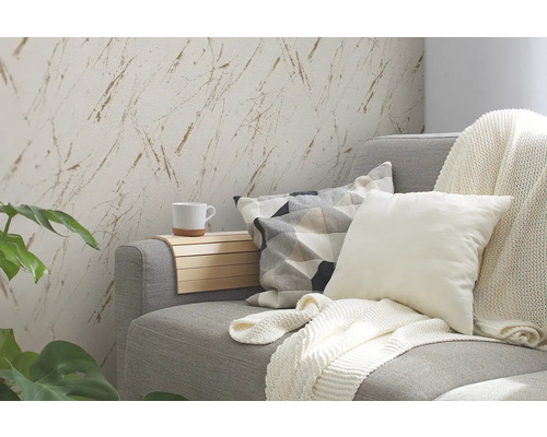 Wohnzimmer mit grauer Couch, Kissen, Decke und Wandtapete mit Marmorierung