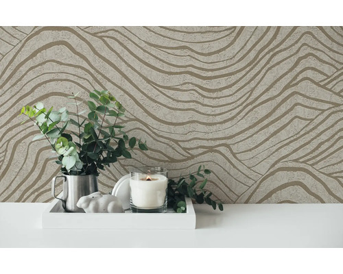 Dekorative Tapete mit wellenförmigem Muster als Hintergrund für ein Arrangement mit Kerze und Pflanzen.