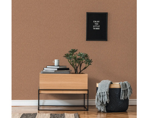 Raumansicht mit Korktapete, Nachttisch, Pflanze und Dekoration