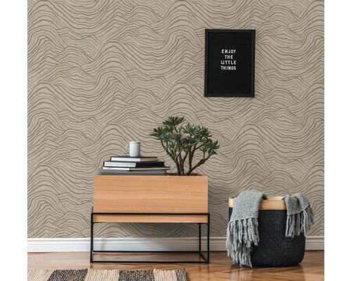 Dekorative Wand mit Tapete im Wellenmuster, Kommode, Korb, Zimmerpflanze und Dekorationsgegenstände
