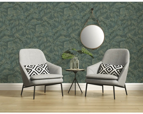Zwei Sessel vor einer Wand mit Blattmuster-Tapete, darüber ein runder Spiegel