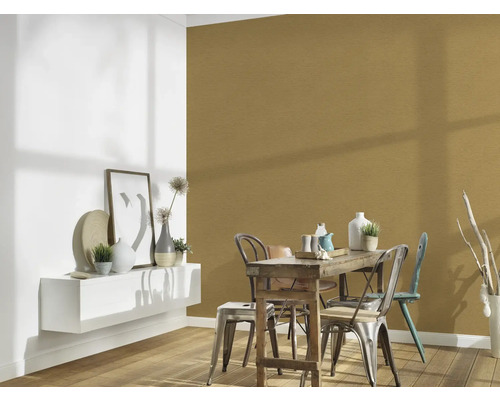 Esszimmer mit Holztisch, Stühlen und Wandgestaltung in Gold