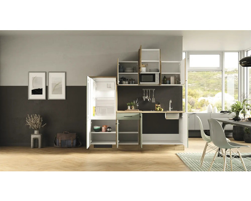 Komplette Küchenzeile mit Kühlschrank, Spüle, Mikrowelle und Schränken in einem hellen, modernen Küchendesign.