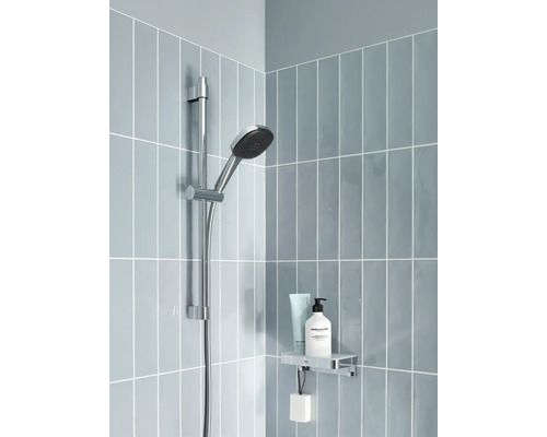 Duschstange mit Handbrause, Ablage und Kosmetikprodukten in einem Badezimmer mit blauen Fliesen.