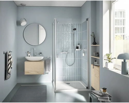 Badezimmer mit Dusche, Waschtisch und Spiegel in hellem Design