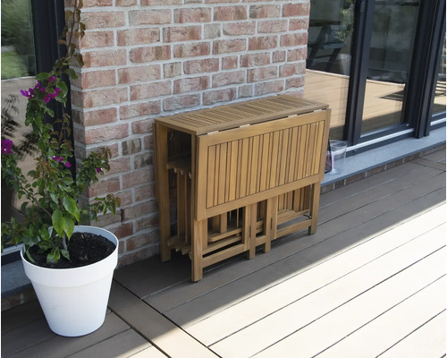 Zusammengeklappter Holzgartentisch mit Stühlen auf einer Terrasse