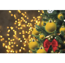 Geschmückter Weihnachtsbaum mit Kugeln und Schleife vor Bokeh-Hintergrund