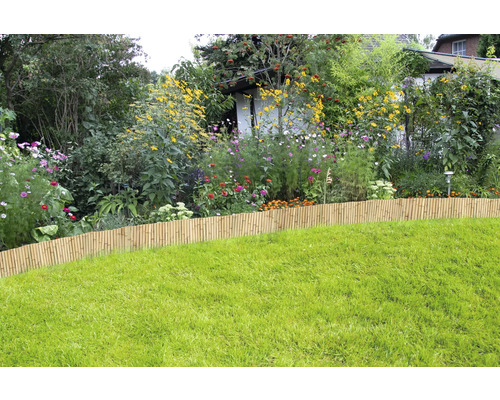 Blick auf einen Garten mit Rasenfläche und Beeteinfassung aus Bambus