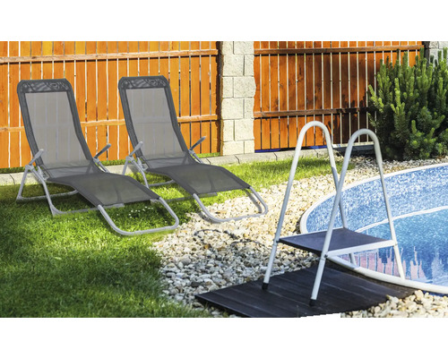 Zwei Liegestühle neben einem Pool mit einer Leiter