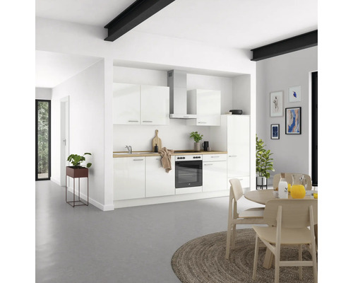 Helle Küche mit weißen Schränken, Dunstabzugshaube und Holzarbeitsplatte in einem hellen Raum.