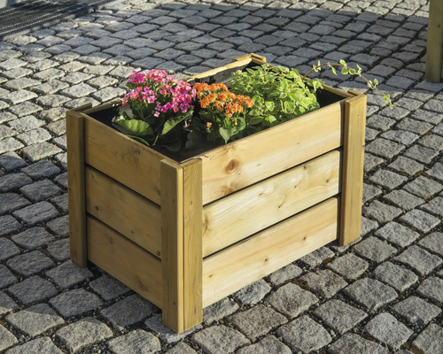 Blumenkasten aus Holz mit Pflanzen auf Pflastersteinen