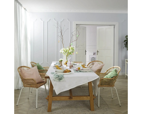 Esstisch mit Osterdekoration, Rattan-Stühlen und heller Farbgestaltung für ein freundliches Ambiente