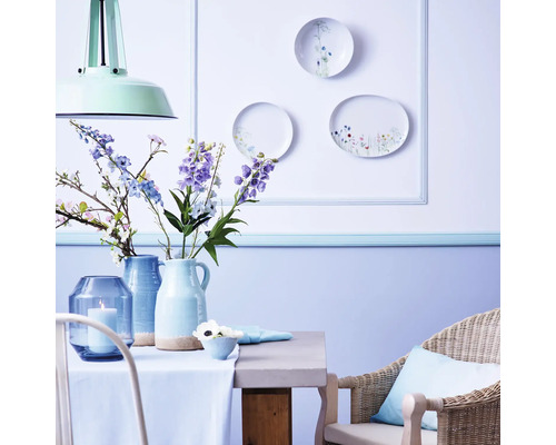 Dekorativer Essbereich mit Tisch, Stuhl, Vasen, Blumen und Wandtellern