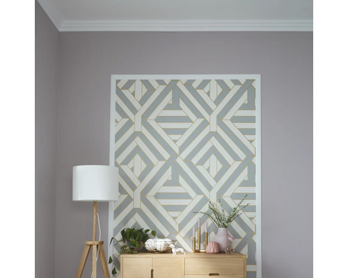 Wohnzimmer mit geometrischer Mustertapete, Holzkommode und Stehlampe