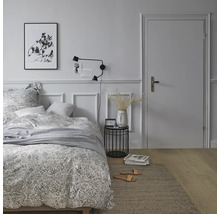 Schlafzimmer mit Bett, Nachttisch, Lampe und Teppich