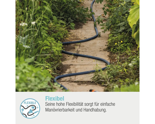 Blauer Gartenschlauch liegt auf einem Weg zwischen Pflanzen