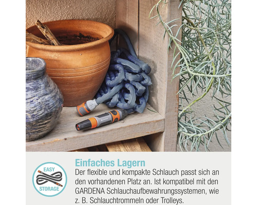 Gardena Textilschlauch mit Spritze auf Holzregal neben Pflanztöpfen