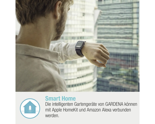 Ein Mann mit einer Smartwatch vor einem Fenster mit Blick auf ein Gebäude.