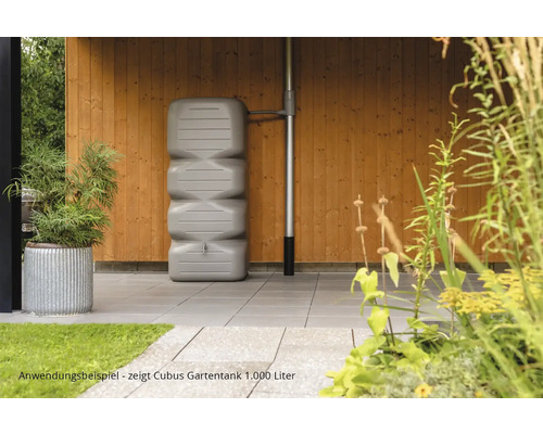 Gartenszene mit einem grauen 1000 Liter Cubus Regentank an einer Holzwand