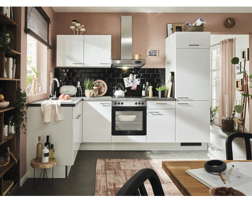 Helle Küche mit weißen Schränken, Spüle und Elektrogeräten vor schwarzem Fliesenspiegel