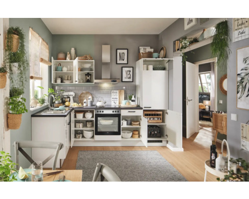 Helle Küche mit weißen Schränken, Arbeitsplatte und verschiedenen Küchenutensilien.