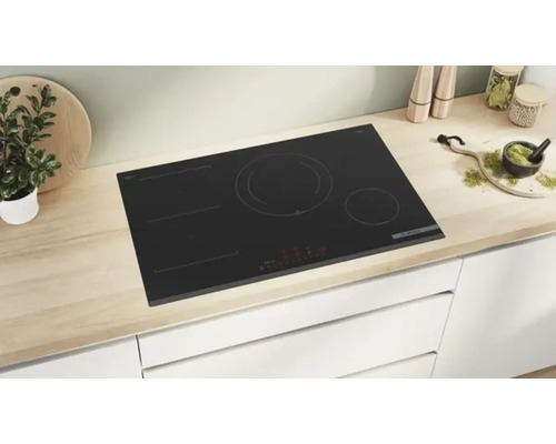 Schwarzes Induktionskochfeld in einer hellen Küche.