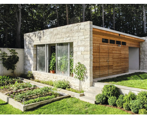 Außenansicht eines modernen Gartenhauses mit Steinfassade, Holzverkleidung und Gemüsebeet