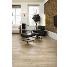 Helles Wohnzimmer mit Holzboden, Sessel und Stehlampe.