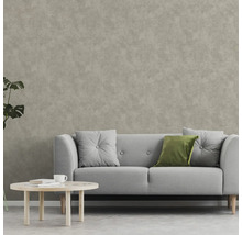 Wohnzimmer mit Sofa, Kissen und Couchtisch vor einer Wandtapete