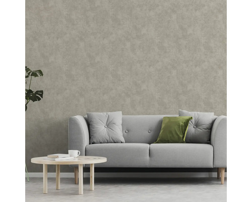 Wohnzimmer mit Sofa, Kissen und Couchtisch vor einer Wandtapete