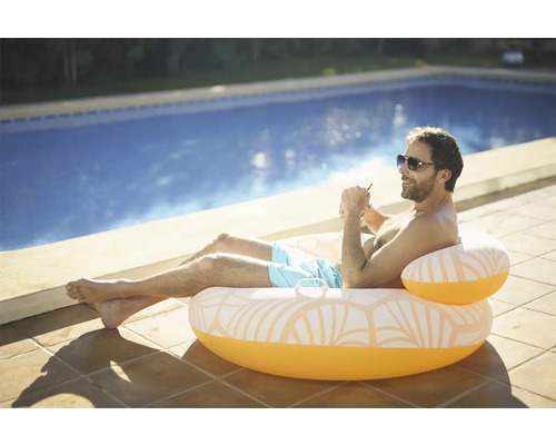 Mann entspannt auf einem aufblasbaren Pool-Sessel am Pool