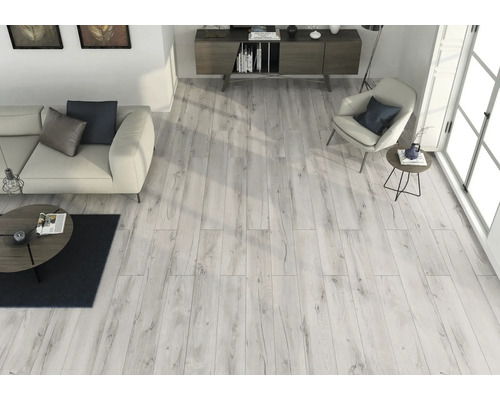 Heller Wohnraum mit Holzboden, Sofa, Sessel und Anrichte