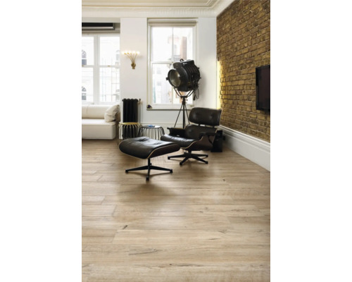 Heller Wohnraum mit Holzboden, Sessel und Stehlampe