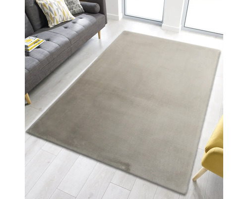 Rechteckiger Teppich im Wohnzimmer neben einem grauen Sofa