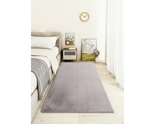 Grauer Teppich im Schlafzimmer mit Bett, Nachttisch und Dekoration