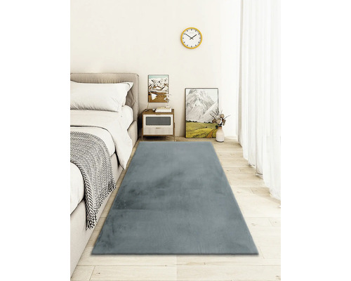 Schlafzimmer mit Bett, Nachttisch und grauem Teppich
