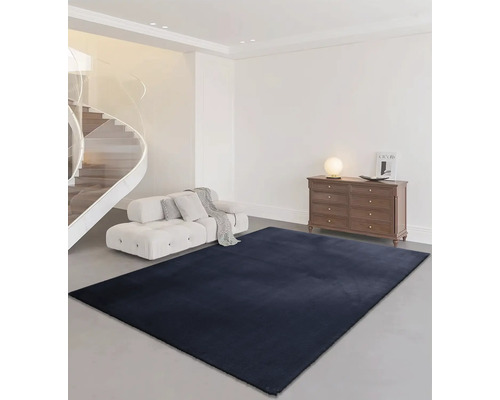 Wohnzimmer mit Treppe, Sofa, Kommode und rechteckigem Teppich