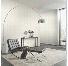 Wohnzimmer mit Tapete, Sessel, Hocker und Stehlampe.
