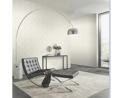 Wohnzimmer mit Tapete, Sessel, Hocker und Stehlampe.