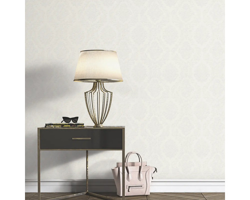 Szene mit gemusterter Tapete, Nachttisch, Lampe und Handtasche