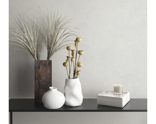 Dekoratives Stillleben mit Vasen, Ziergräsern, Zierästen und Kerze auf einer Konsole