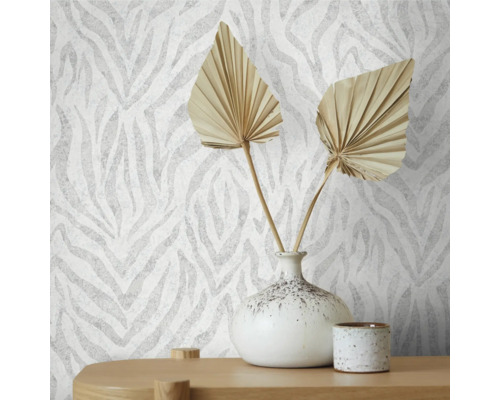 Nahaufnahme einer Wand mit Tapete im Zebra-Stil, dekoriert mit einer Vase und getrockneten Blättern