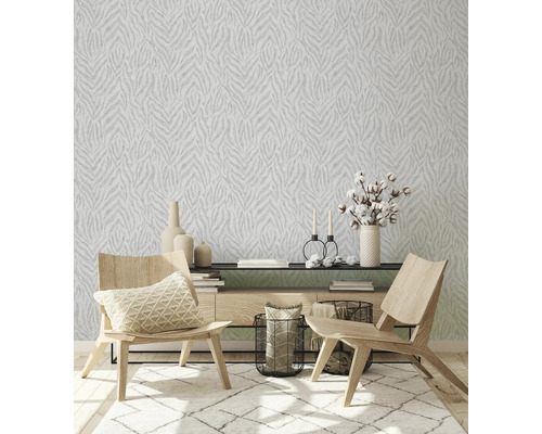 Wohnzimmer mit gemusterter Tapete, Teppich und Holzmöbeln.