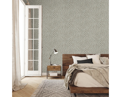 Schlafzimmer mit gemusterter Tapete, Bett, Nachttisch und Teppich